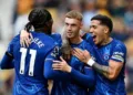 Cole Palmer celebrates with Chelsea teammates after scoring in a Premier League match.