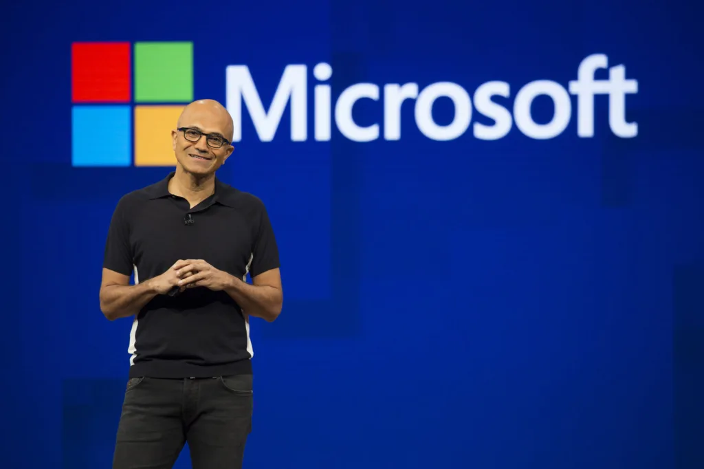 Satya Nadella speaking on stage at a Microsoft event, highlighting the role of computational thinking in software development.